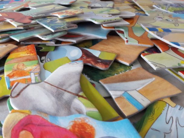 Puzzle Kinder Puzzle Chaos. Alle Puzzleteile zerstreut im Kinderzimmer - was Tun? Ordnungs-Idee