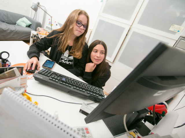 2 Kinder sitzen vor einem Computer 